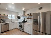 Bright kitchen features stainless steel appliances, white cabinets, and a window over the sink at 1622 N 17Th Ave, Phoenix, AZ 85007