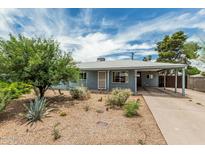 Charming single-story home with desert landscaping and a covered carport on a sunny day at 2019 W Stella Ln, Phoenix, AZ 85015