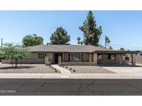 Charming single-story home featuring a brick facade, covered parking, and low-maintenance landscaping at 2156 E Cairo Dr, Tempe, AZ 85282