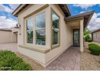 Inviting home exterior featuring brick pathway, desert landscaping, and large window at 36047 N Copper Hollow Way, Queen Creek, AZ 85140