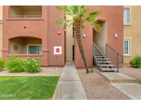 Apartment exterior with well-kept landscaping, stairs to upper units and a palm tree at 5401 E Van Buren St # 1004, Phoenix, AZ 85008