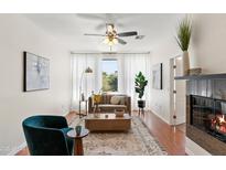 Bright living room with elegant decor, fireplace, and a ceiling fan creating a welcoming atmosphere at 6900 E Princess Dr # 2247, Phoenix, AZ 85054