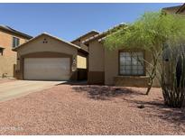 Charming single-story home with a two-car garage, xeriscape landscaping, and mature desert tree at 9224 W Raymond St, Tolleson, AZ 85353