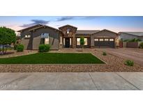 Beautiful single-Gathering home with a well-manicured lawn, desert landscaping, and a charming stone-accented entrance at 9448 W Villa Hermosa --, Peoria, AZ 85383