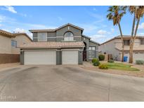 Charming two-story home with a three-car garage, desert landscaping, and a spacious driveway at 1405 S Honeysuckle Cir, Gilbert, AZ 85296