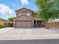 Charming two-story home featuring a two-car garage, landscaped front yard, and inviting covered porch at 14626 N 132Nd Ave, Surprise, AZ 85379
