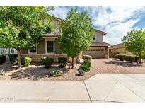 Charming home featuring a well-maintained yard with stone accents and a brick driveway at 14727 W Pasadena Ave, Litchfield Park, AZ 85340