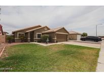 Charming single-story home featuring a well-manicured lawn and desert landscaping at 16036 W Desert Bloom St, Goodyear, AZ 85338