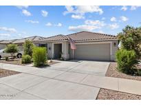 Charming single-story home with a two-car garage, covered porch, and desert landscaping at 17461 W Molly Ln, Surprise, AZ 85387