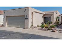 Charming home exterior with a two-car garage and desert landscaping with succulents and flower pots at 2326 E Evans Dr, Phoenix, AZ 85022