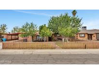 Charming home featuring a well-manicured lawn, mature trees, and a quaint picket fence at 2907 W Townley Ave, Phoenix, AZ 85051