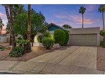 Charming home exterior with a well-maintained lawn, mature trees, and attached two-car garage at 2916 S Revere Cir, Mesa, AZ 85210