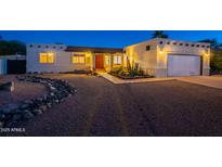 Charming home featuring desert landscaping, warm exterior lighting, and a welcoming front entrance at 3133 E Claire Dr, Phoenix, AZ 85032
