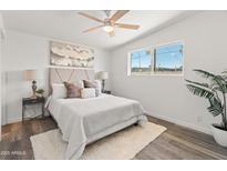 Bright bedroom with white walls, wood-look flooring, ceiling fan, and cozy decor at 3824 W Puget Ave, Phoenix, AZ 85051