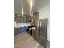 Modern kitchen features stainless steel appliances, gray cabinetry, and a stylish backsplash at 3824 W Puget Ave, Phoenix, AZ 85051