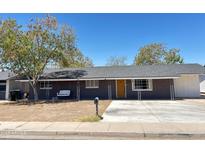 Charming single-story home with a welcoming yellow front door and swing on the front porch at 512 N Ironwood --, Mesa, AZ 85201