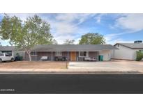 Charming single-story home featuring a cozy front porch with hanging swing and modern outdoor seating at 512 N Ironwood --, Mesa, AZ 85201