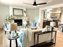 Inviting living room with stone fireplace, modern decor, and open floor plan into kitchen area at 6923 E Hubbell St, Scottsdale, AZ 85257