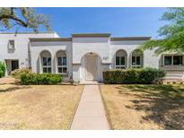 Charming home featuring arched windows, a welcoming front yard, and a unique front door design at 8328 E Chaparral Rd, Scottsdale, AZ 85250