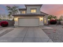 Two-story home with tan stucco, a two car garage and a driveway under an colorful evening sky at 8450 S Stephanie Ln, Tempe, AZ 85284