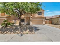 Inviting two-story home featuring a two-car garage, desert landscaping and mature shade tree in the front yard at 9948 W Chipman Rd, Tolleson, AZ 85353