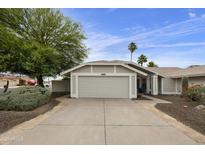 Charming single-story home featuring a neutral color palette, two-car garage and desert landscaping at 11430 N 109Th St, Scottsdale, AZ 85259