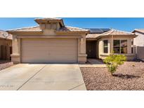 Charming home featuring a two-car garage, desert landscaping, and solar panels for energy efficiency at 1634 E Harwell Rd, Phoenix, AZ 85042