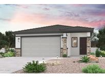 Charming single-story home featuring a stone-accented facade, desert landscaping, and a two-car garage at 17217 W Daley Ln, Surprise, AZ 85387