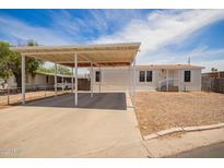 Charming single-story home featuring a covered carport and a low-maintenance desert landscape at 231 N 88Th Way, Mesa, AZ 85207