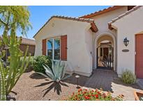Charming home entrance featuring desert landscaping, an arched gate, and a terracotta-tiled roof at 30406 N 54Th St, Cave Creek, AZ 85331