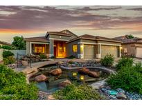 Stunning home featuring a decorative pond, three-car garage, and manicured desert landscaping at 321 W Brooks St, Gilbert, AZ 85233
