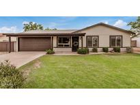 Charming single-story home with a lush green lawn, well-maintained landscaping, and neutral color palette at 3619 E Marmora St, Phoenix, AZ 85032