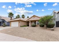 Charming single-story home with desert landscaping, a two-car garage, and palm trees in a desirable location at 420 N Leoma Ln, Chandler, AZ 85225
