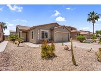 Charming single-story home featuring desert landscaping, a two-car garage, and a covered front porch at 43787 W Colby Dr, Maricopa, AZ 85138