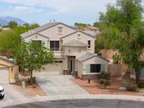 Charming two-story home featuring a three-car garage and desert landscaping at 44890 W Desert Garden Rd, Maricopa, AZ 85139