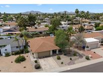 A sunny aerial view of a single story home with desert landscaping and a two car garage in a well-kept community at 6725 E Kings Ave, Scottsdale, AZ 85254
