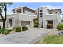 Stunning two-story home with a circular driveway, desert landscaping, and a three-car garage at 7262 E Lupine Ave, Scottsdale, AZ 85260