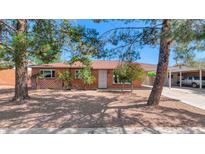 Charming single-story home with brick exterior, mature trees, and a well-maintained front yard at 8140 E Mitchell Dr, Scottsdale, AZ 85251