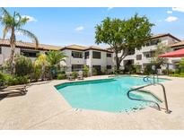 A community pool surrounded by lush landscaping and apartment buildings offers residents a relaxing oasis at 9990 N Scottsdale Rd # 2029, Paradise Valley, AZ 85253