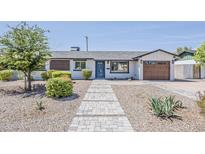 Charming single-story home boasts a blue front door, updated landscaping, and a spacious one-car garage at 1003 E Marigold Ln, Tempe, AZ 85288