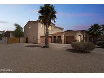 Spacious two-story home featuring a three-car garage, desert landscaping, and a mature palm tree at 120 N Pottebaum Rd, Casa Grande, AZ 85122