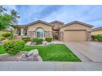 Charming single-story home featuring manicured lawn, stone accents, and attached two-car garage at 13353 W Gloria Ln, Peoria, AZ 85383