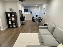 Open-concept living room featuring hardwood floors and a round dining table near the kitchen at 1449 E Highland Ave # 25, Phoenix, AZ 85014