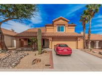 Charming two-story home with a tile roof, desert landscaping, and a red car parked in the driveway at 16017 S 12Th Pl, Phoenix, AZ 85048
