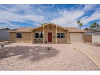 Charming single-story home with desert landscaping, attached garage, and red front door at 3620 E Ludlow Dr, Phoenix, AZ 85032