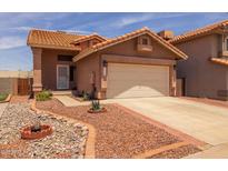 Charming single-story home with a well-manicured desert landscape and a two-car garage at 4114 E Muirwood Dr, Phoenix, AZ 85048