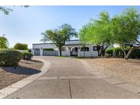 Stunning single story home with white stucco, dark trim, desert landscaping, and a spacious driveway with gated garages at 5404 N 41St St, Phoenix, AZ 85018