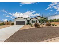 Charming single-story home featuring desert landscaping, gray stucco, and a spacious driveway at 5670 E Singletree St, Apache Junction, AZ 85119
