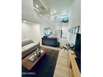 Bright living room featuring a modern staircase, stylish decor, and neutral color palette at 727 W Maryland Ave # 1, Phoenix, AZ 85013