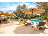 Inviting backyard with a sparkling pool, lounge chairs, and outdoor kitchen with barbeque for relaxing and entertaining at 7307 N 17Th Ave, Phoenix, AZ 85021